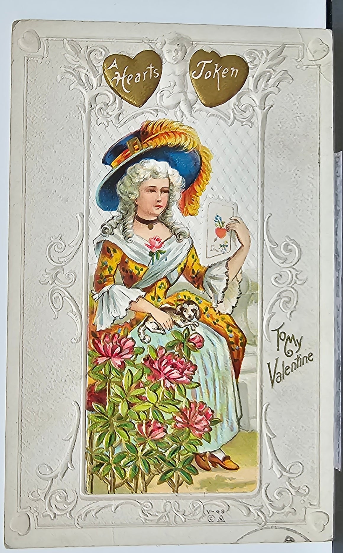 Valentine Postcard Embossed Victorian Dressed Woman Holding Card Small Dog on Lap In Garden