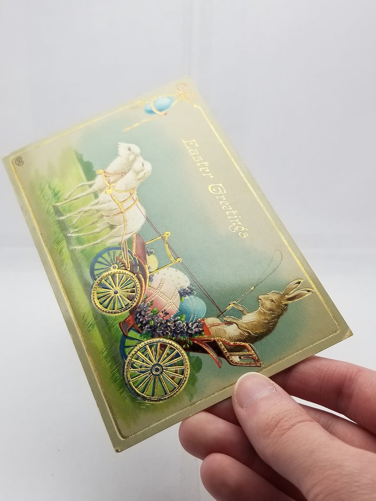 Easter Postcard Fantasy Card Bunny Rabbit Riding in Wagon Filled with Eggs Pulled by Baby Lambs EAS Pub Gel Finish Gold Embossed