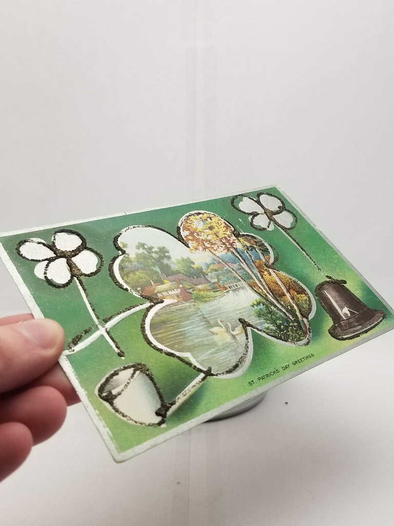 St Patrick's Day Postcard Silver Embossed Card Applied Glitter Landscape Scene with Pond in Ireland Pipe & Shamrocks