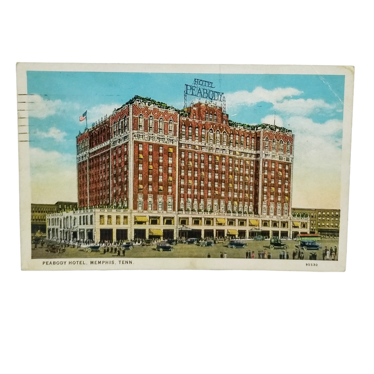 A vintage postcard showing the historic Peabody Hotel in Memphis, Tennessee. The postcard features a detailed illustration of the red brick hotel with white trim, a blue sky with clouds, and small figures of people and cars at the base.