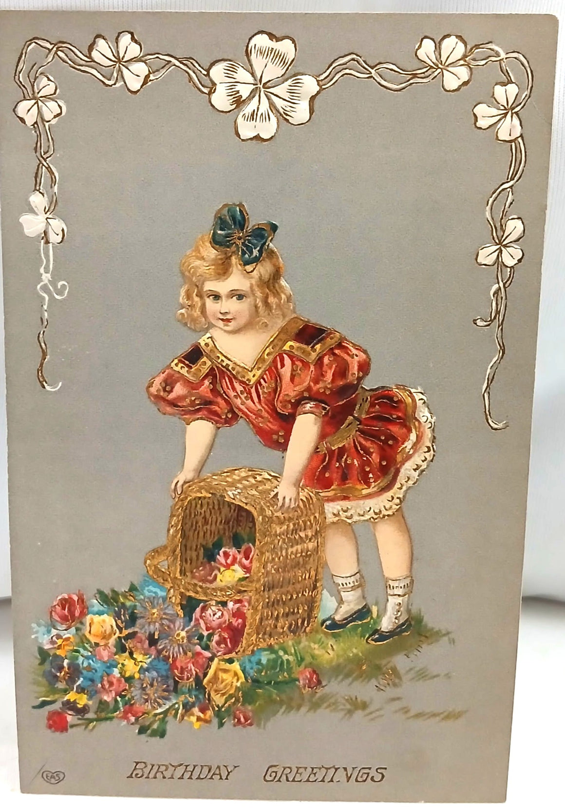 Vintage-style greeting card with a child holding a basket of flowers and decorative elements.