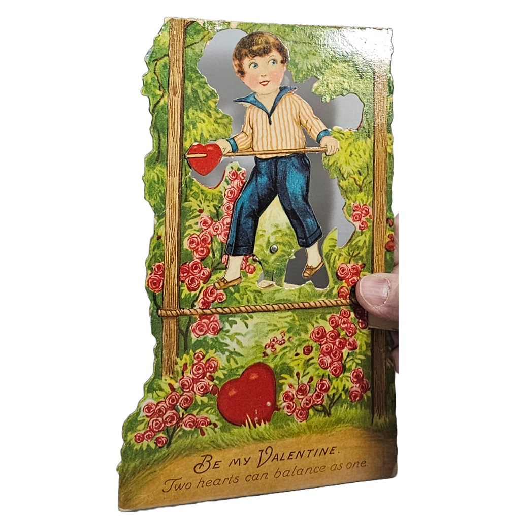 Vintage Die Cut Valentine Mechanical Card Boy Balancing on Rope Among Roses in Forest