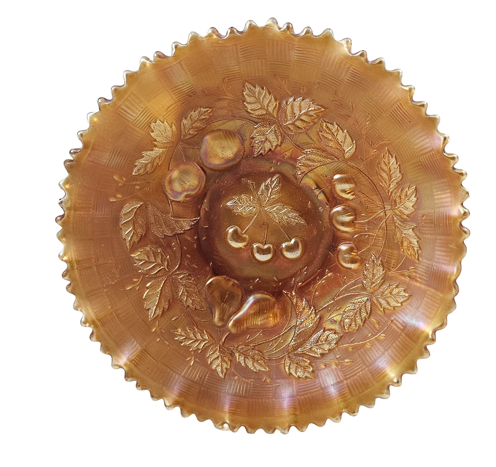 Decorative amber glass bowl with leaf and fruit patterns on a white background