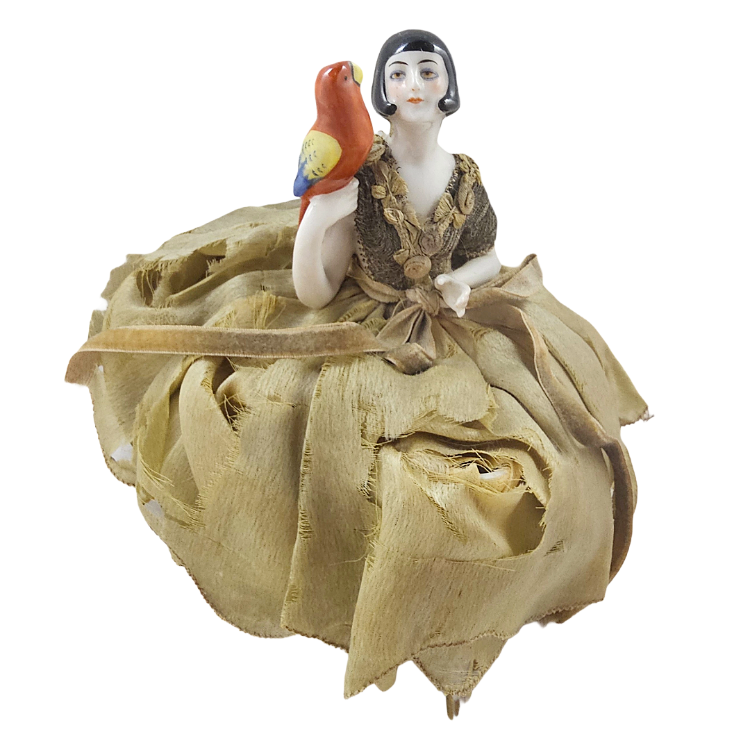german porcelain half doll from the art deco era in flapper style holding a parrot