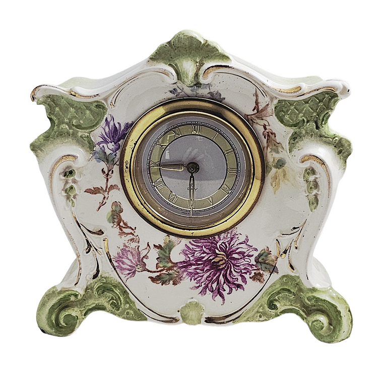 a german porcelain mantle clock with green decor and purple flowers