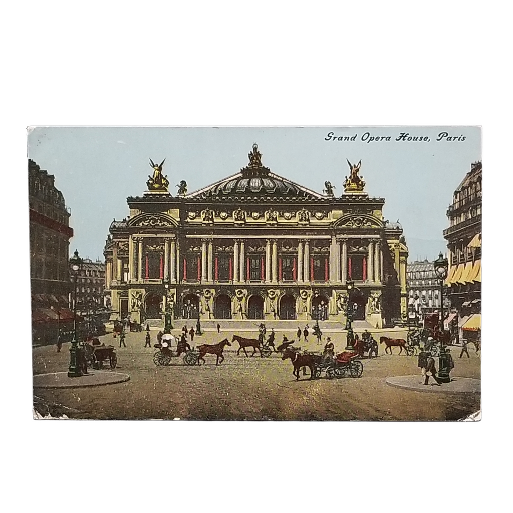 A vintage postcard depicting the Grand Opera House in Paris, with horse-drawn carriages and pedestrians in the foreground. The postcard is shown against a plain white background.