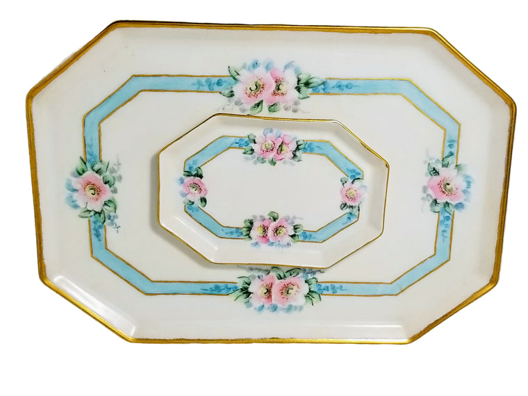 A Limoges porcelain dresser set with two trays featuring wild roses in pink with cream ground and gold trim.