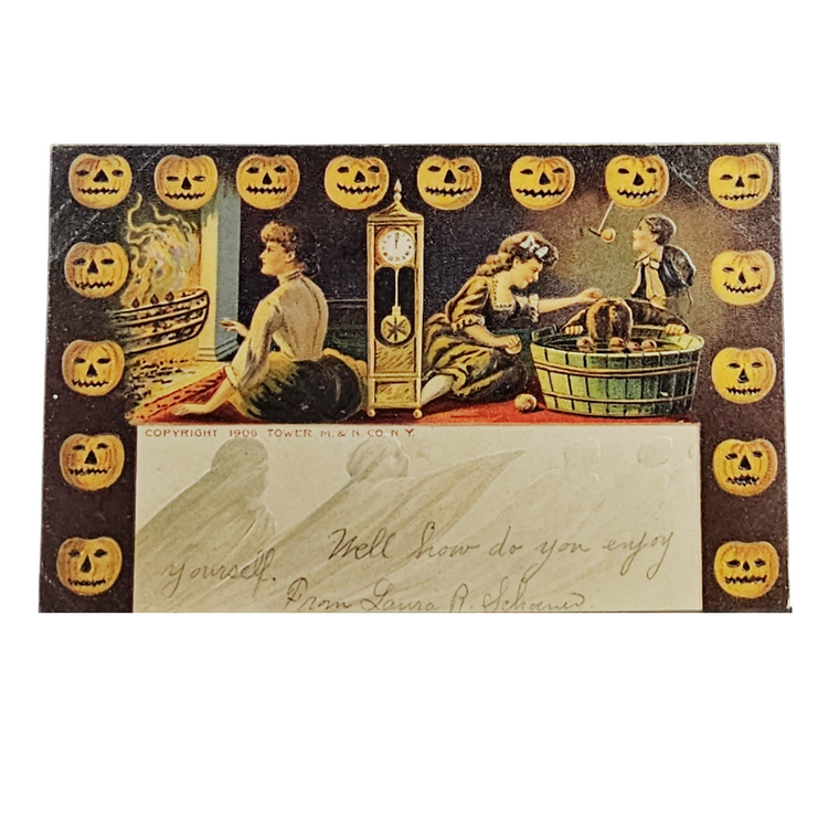 A vintage Halloween greeting card or postcard featuring illustrated figures around a clock and pumpkins, with a large blank address panel at the bottom and a border of carved pumpkin faces.