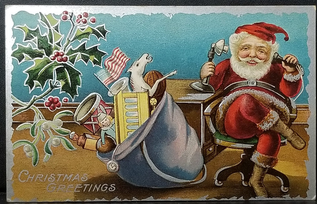 Christmas Postcard Santa Claus Talking on Telephone Next to Full Toy Bag with American Flag Sticking Up Silver Trim