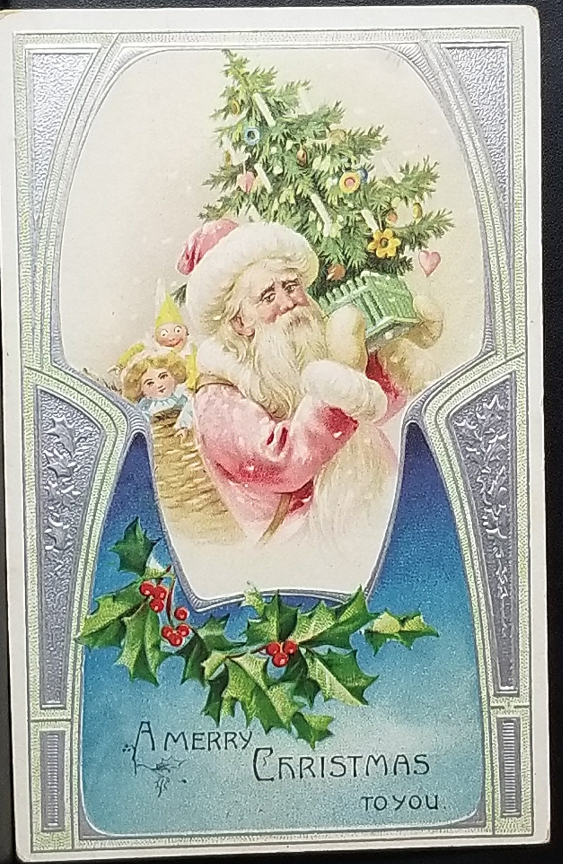 Christmas Postcard Santa Claus in Pink Robe Holding Tree & Toys Silver Background