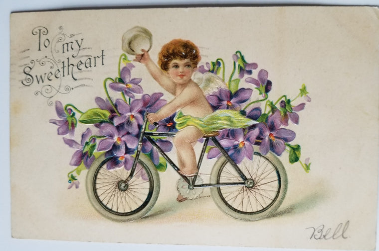 Valentine Postcard Cupid Riding Bicycle Covered in Lilacs B.W. 286