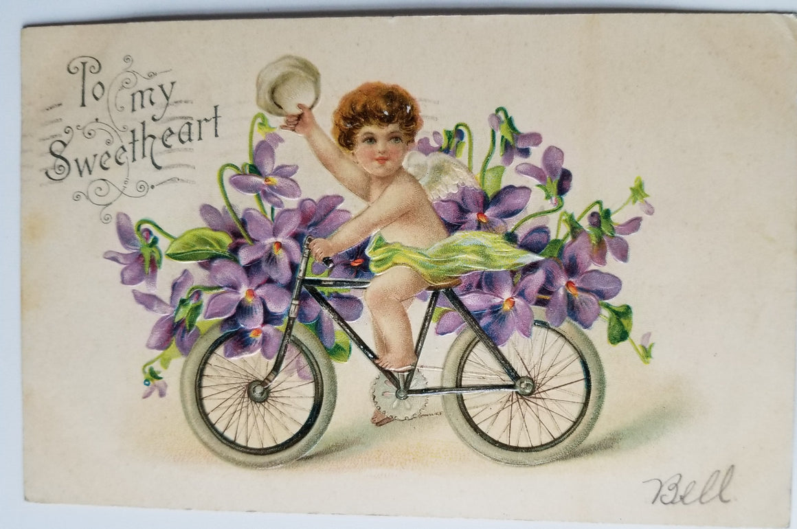 Valentine Postcard Cupid Riding Bicycle Covered in Lilacs B.W. 286