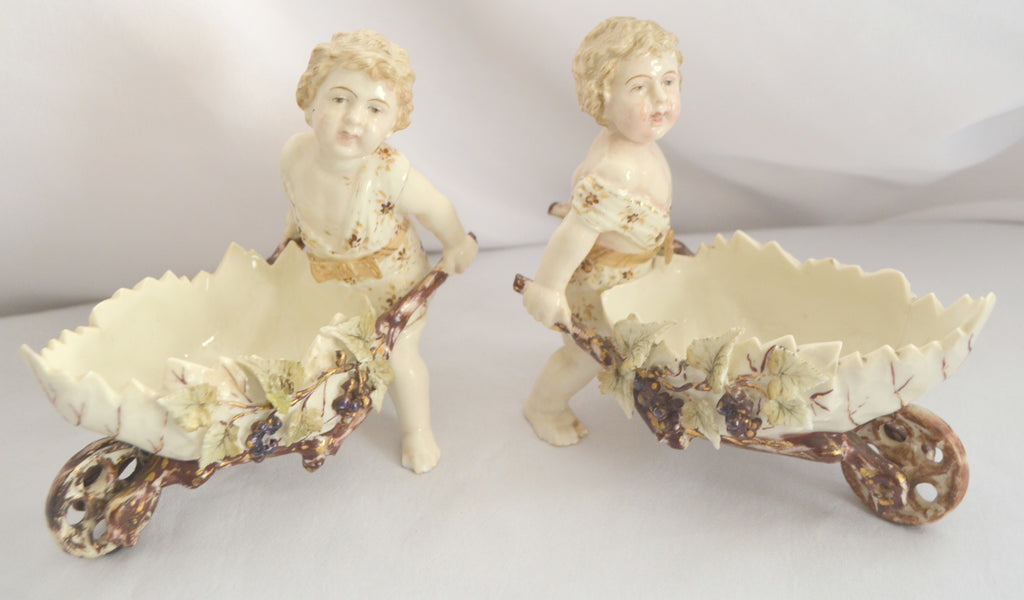 Volkstedt Thuringia Germany Eckert Porcelain Bisque Garden Cherubs Pair Putti Hand Painted Pushing Wheelbarrows with Moving Wheels
