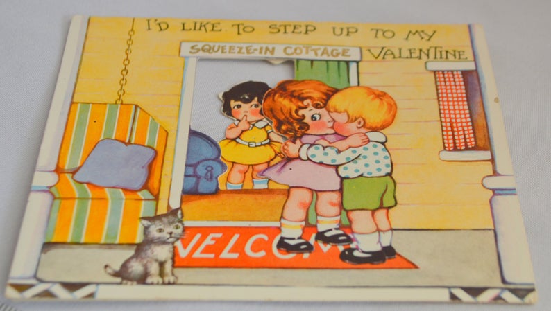 Antique Valentine's Day Card Die Cut Embossed Stand Up Two Children Kissing in Doorway Third Girl Watches with Kitty Cat